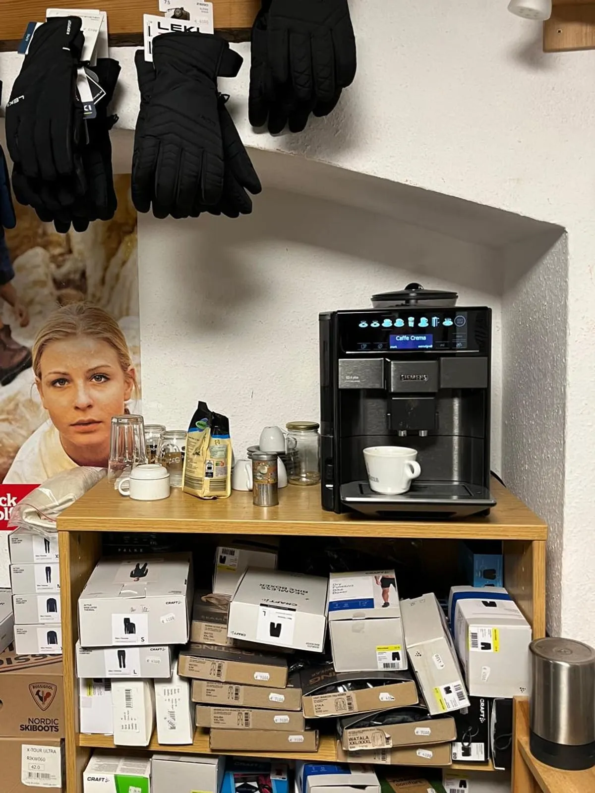 Kaffeemaschine im Laden, darunter Kartons mit Funktionsunterwäsche